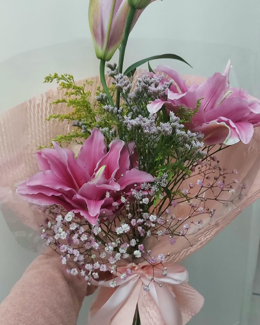 Buquê nº 08 — Lírio Suave: Lírios rosa em plena abertura com gipsofila e limonium, num embrulho rosé bem delicado