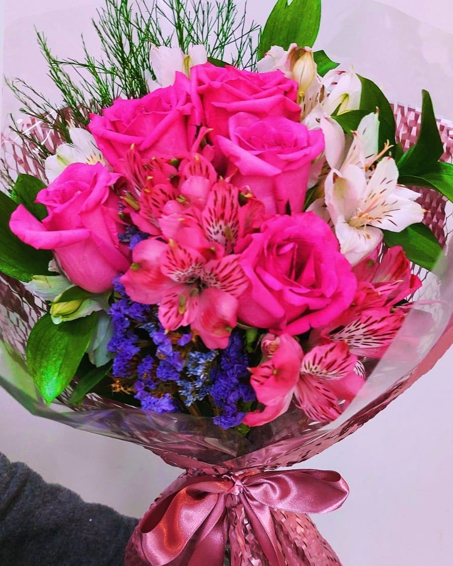 Buquê nº 13 — Pink Vibrante: Rosas pink intensas com astromélias e statice azul, em celofane rosé com laço de cetim