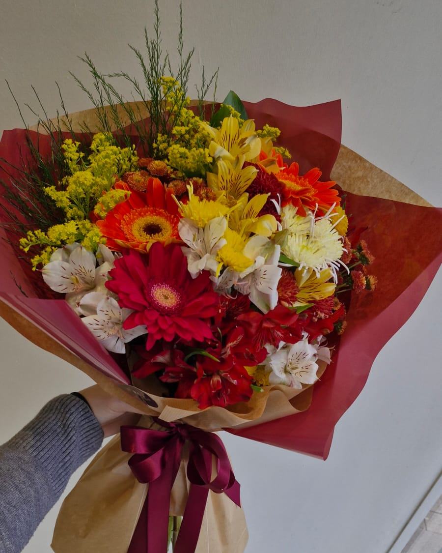 Buquê nº 17 — Explosão Tropical: Gérberas laranja e pink com astromélias, crisântemos e tango, em papel vinho com kraft